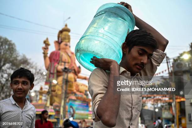 Man carries a water can amid an ongoing water crisis in Bengaluru on March 14, 2024.