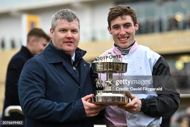 Gloucestershire , United Kingdom - 14 March 2024; Jockey Jack Kennedy, right, and trainer Gordon Elliott celebrate with the trophy after winning the...