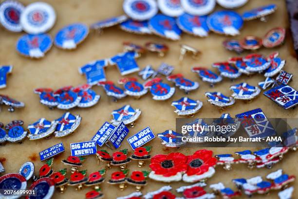 Rangers enamel pin badges being sold at a merchandise stall ahead of the UEFA Europa League 2023/24 round of 16 second leg match between Rangers FC...