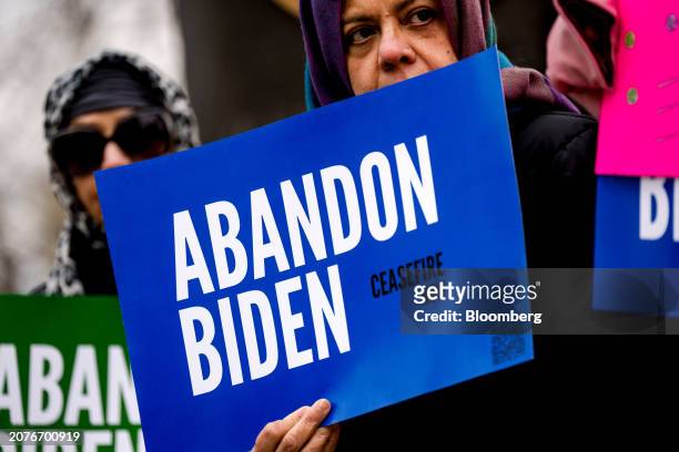 Demonstrators with the group "Abandon Biden" hold signs during a news conference prior to President Joe Biden's visit in Saginaw, Michigan, US, on...