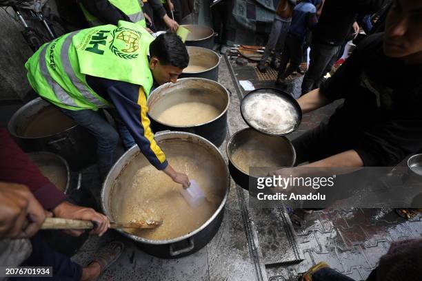 Turkish NGO IHH Humanitarian Relief Foundation workers distribute food on the 4th day of Ramadan to Palestinians who fled the attacks and took refuge...