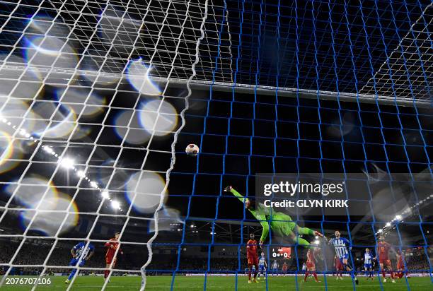 Brighton's English striker Danny Welbeck scores the opening goal past Roma's Serbian goalkeeper Mile Svilar during the UEFA Europa League round of 16...