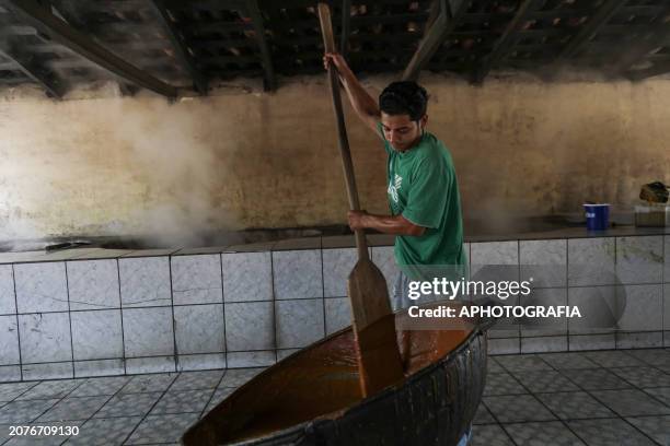 Worker whips cool 'panela' candy in a milling oven during the raw cane sugar festival in the municipality of San Lorenzo on March 14, 2024 in San...