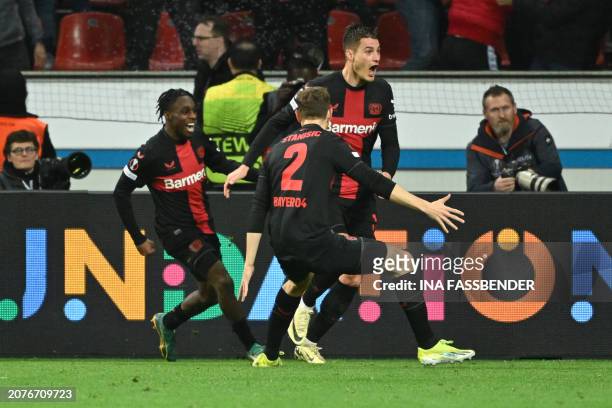 Bayer Leverkusen's Czech forward Patrik Schick celebrates scoring the 3-2 goal with Bayer Leverkusen's Dutch defender Jeremie Frimpong and Bayer...