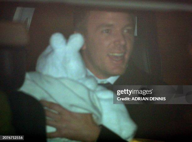 British film director Guy Ritchie gets into his awaiting limousine holding 8-month-old son Rocco after his christening at Dornoch Cathedral, 21...