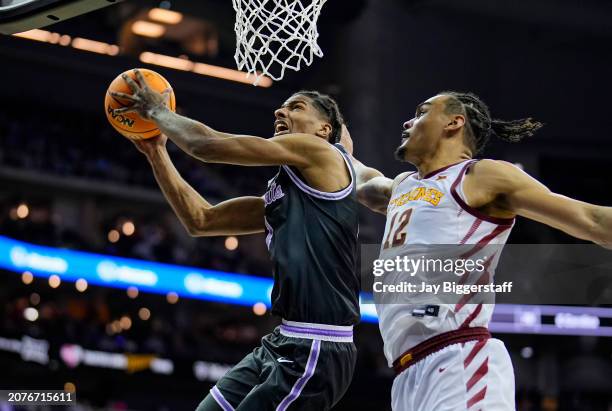 David N'Guessan of the Kansas State Wildcats shoots against Robert Jones of the Iowa State Cyclones during the second half of a quarterfinal game of...