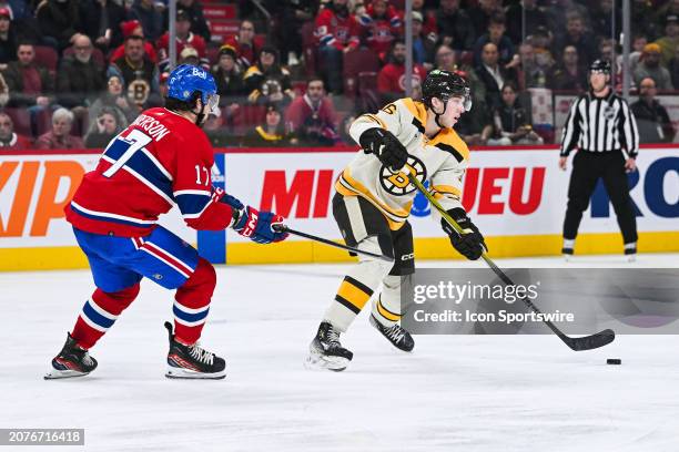Boston Bruins defenseman Mason Lohrei plays the puck against Montreal Canadiens right wing Josh Anderson during the Boston Bruins versus the Montreal...