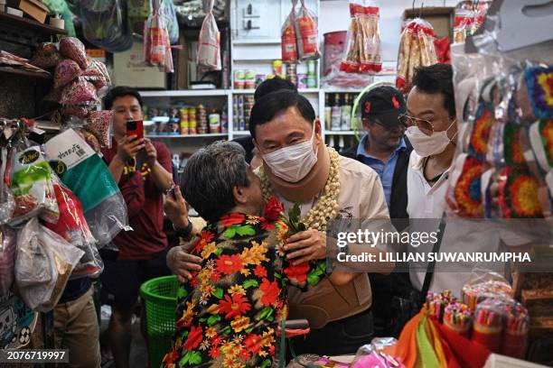 Thailand's former prime minister Thaksin Shinawatra receives a rose from a vendor at Warorot Market in Chiang Mai on March 15, 2024. Thailand's...