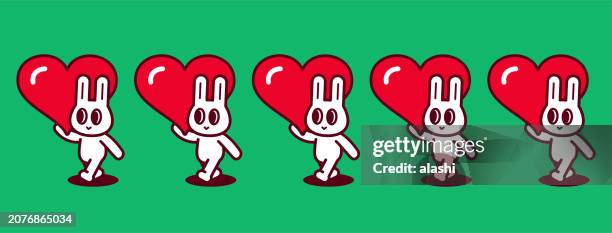 a group of cute rabbits, each carrying a big love heart, walking in a straight line - world kindness day stock illustrations