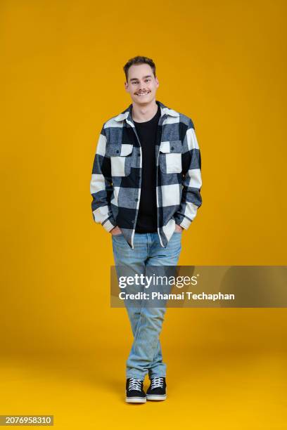 happy man in front of plain background - mani in tasca foto e immagini stock