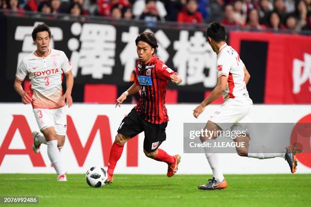 Yoshiaki Komai of Consadole Sapporo competes for the ball against Kazuki Kushibiki and Ryuji Izumi of Nagoya Grampus during the J.League J1 match...