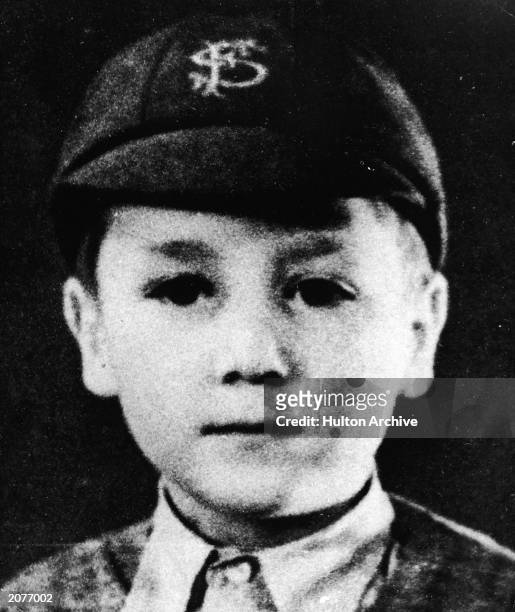 Headshot portrait of British musician and songwriter John Lennon , of the pop group The Beatles, as a young boy in a school uniform and cap, circa...