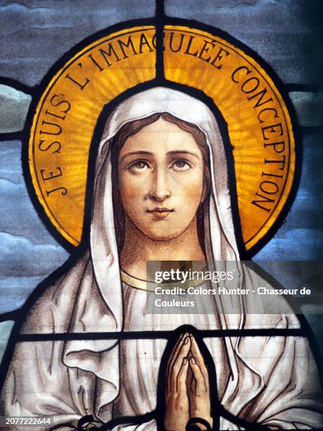 the virgin mary with her hands clasped and her eyes raised to heaven. close-up of an old stained glass window found in an abandoned funeral chapel in the pere lachaise cemetery in paris, france. natural light, colors and patina. - helgon bildbanksfoton och bilder