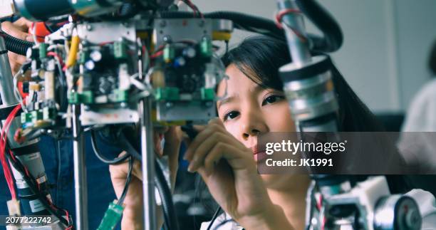 focused students working on advanced robotics - futuristic lab stock pictures, royalty-free photos & images
