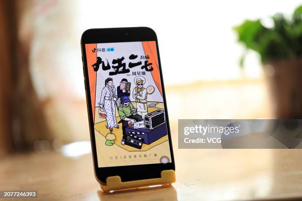 Citizen shows the poster of an online mini drama series on a mobile phone through the video-sharing platform Douyin, which is owned by Chinese tech...