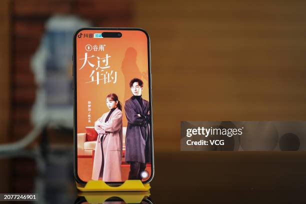 Citizen shows the poster of an online mini drama series on a mobile phone through the video-sharing platform Douyin, which is owned by Chinese tech...