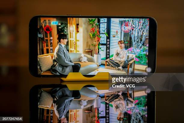 Citizen shows the poster of an online mini drama series on a mobile phone through the video-sharing platform Douyin, which is owned by Chinese tech...