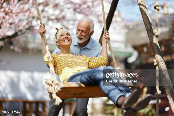 happy senior couple spending a spring day in the backyard. - schaukel stock-fotos und bilder