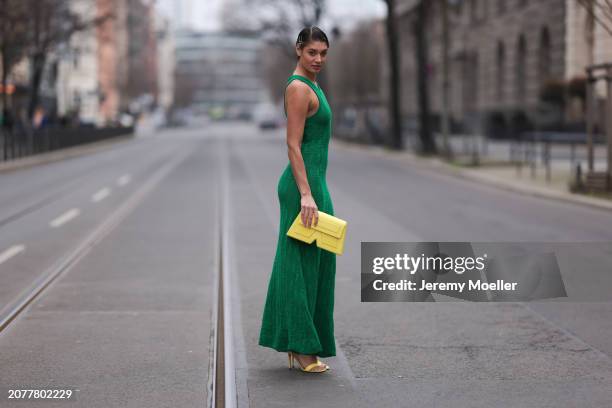 Sarah Posch seen wearing Karl Lagerfeld green long knit dress, Karl Lagerfeld yellow leather clutch bag and Liu Jo yellow leather heels, on March 09,...