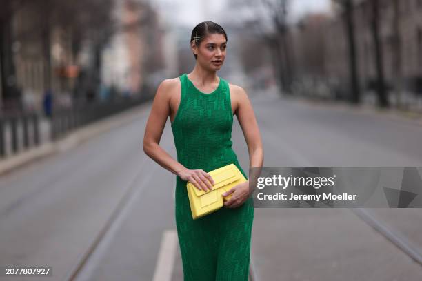 Sarah Posch seen wearing Karl Lagerfeld green long knit dress, Karl Lagerfeld yellow leather clutch bag, on March 09, 2024 in Berlin, Germany.