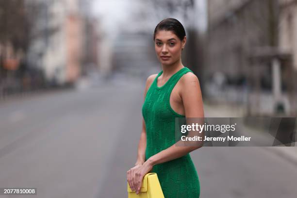 Sarah Posch seen wearing Karl Lagerfeld green long knit dress, Karl Lagerfeld yellow leather clutch bag, on March 09, 2024 in Berlin, Germany.