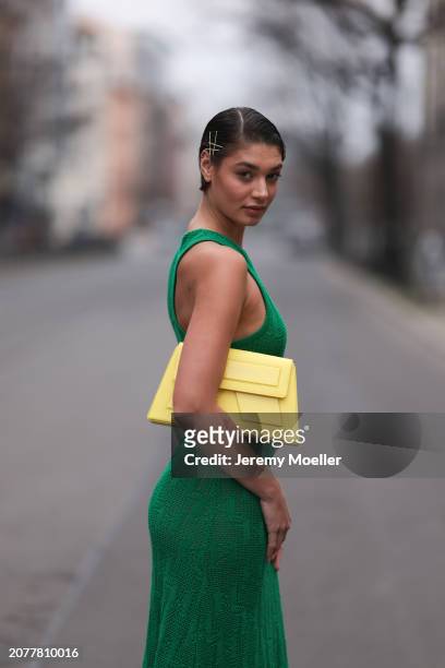 Sarah Posch seen wearing Karl Lagerfeld green long knit dress, Karl Lagerfeld yellow leather clutch bag, on March 09, 2024 in Berlin, Germany.