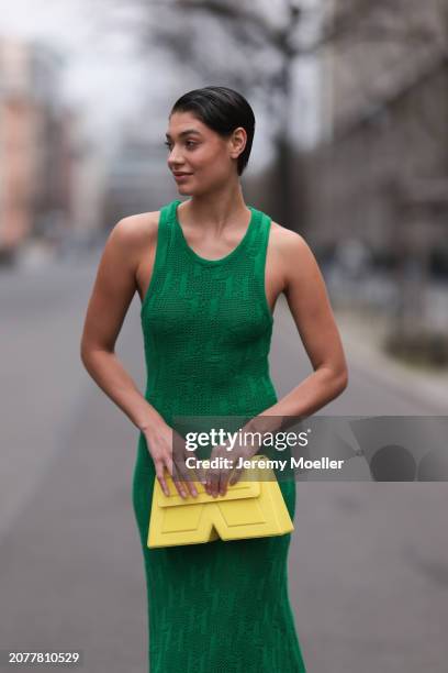 Sarah Posch seen wearing Karl Lagerfeld green long knit dress, Karl Lagerfeld yellow leather clutch bag, on March 09, 2024 in Berlin, Germany.