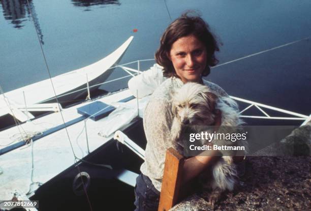 Edith Baumann from West Germany poses on the deck of her trimaran Koala III with her pet dog Schatz ahead of the Observer Single-handed...