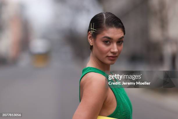 Sarah Posch seen wearing Karl Lagerfeld green long knit dress and Karl Lagerfeld yellow leather clutch bag, on March 09, 2024 in Berlin, Germany.