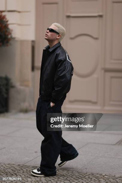 Federico Spinas seen wearing black sunglasses, black cotton basic t-shirt, Review black oversized leather bomber jacket, dark blue baggy denim /...