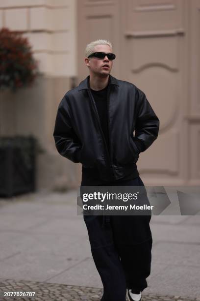 Federico Spinas seen wearing black sunglasses, black cotton basic t-shirt, Review black oversized leather bomber jacket, dark blue baggy denim /...