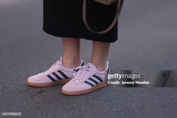 Tugba Kement seen wearing COS black midi long skirtand Adidas Spezial light pink suede leather sneakers, on March 08, 2024 in Hamburg, Germany.