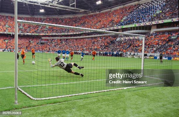 Italy footballer Francesco Toldo dives to save the penalty of Dutch footballer Frank de Boer, the Netherlands' first of the penalty shootout of the...