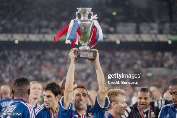 France footballer Youri Djorkaeff raises the trophy above his head after the UEFA Euro 2000 final between France and Italy, at Stadion Feijenoord in...