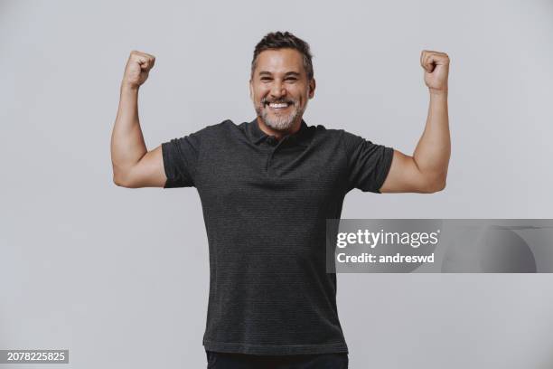 retrato de la fuerza de un hombre con su brazo - flexionar los músculos fotografías e imágenes de stock