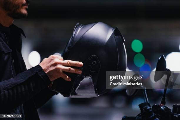 primer plano de un motociclista anónimo sosteniendo un casco - motociclista fotografías e imágenes de stock