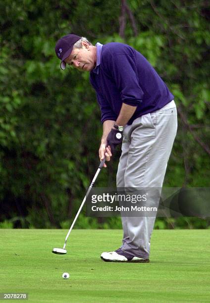 President George W. Bush plays golf with his father at the Arundal Golf Club June 13, 2003 in Arundal, Maine. Bush is on an extended weekend visit to...