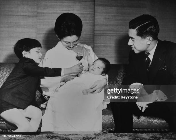 Prince Hiro holding up a rattle for his baby brother, Prince Aya, as their parents, Crown Princess Michiko and Crown Prince Akihito, look on, Tokyo,...