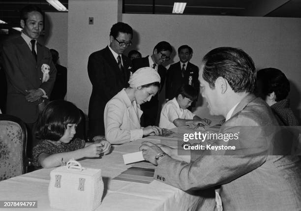 Crown Princess Michiko and two of her children, Princess Nori and Prince Aya, practicing the art of Origami at the World Origami Fair in Tokyo,...