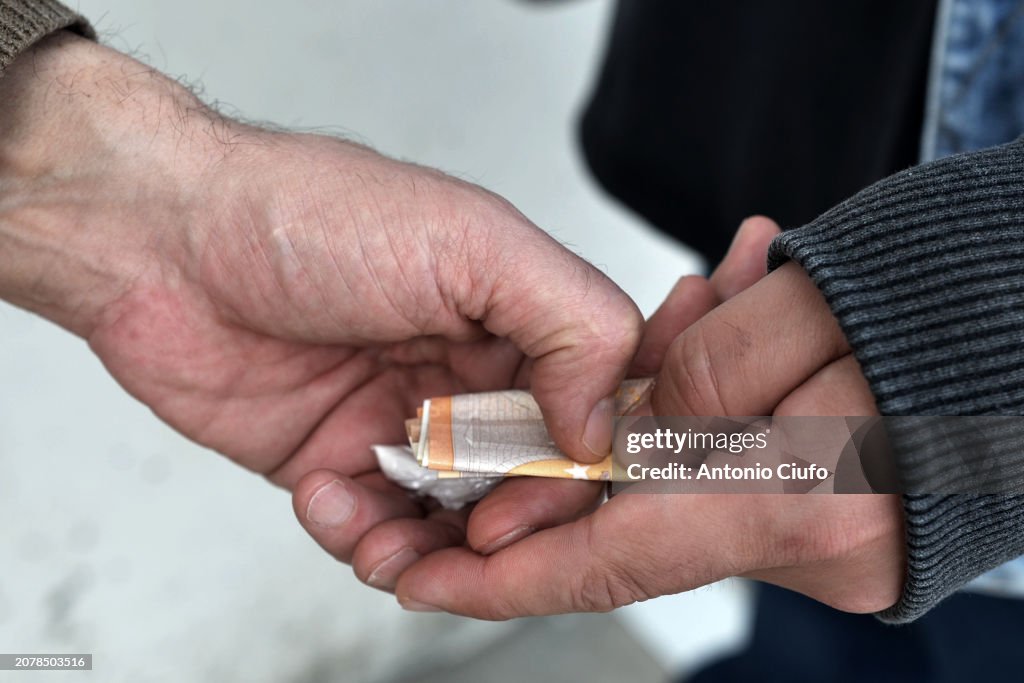 DRUGS - SELLING - ADDICTION - SOCIAL PROBLEMS. Pusher meets the customer on the street to sell him a dose of cocaine