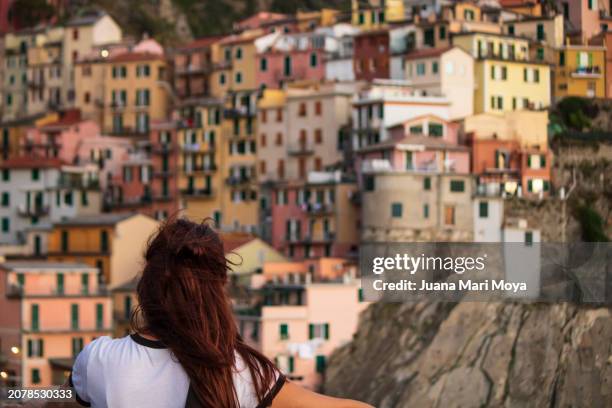 tourist looking at manarola at sunset, cinqueterre, italy. - ligurian sea stock pictures, royalty-free photos & images
