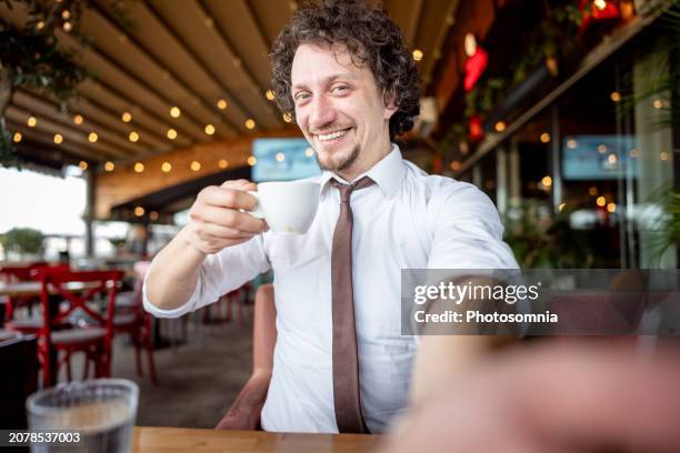 man with necktie taking selfie at cafeteria - entrepreneur stockfoto's en -beelden
