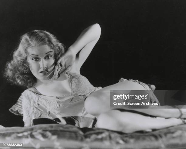 Fay Wray cowers in fear wearing torn dress in a publicity pose for the 1933 version of 'King Kong'.