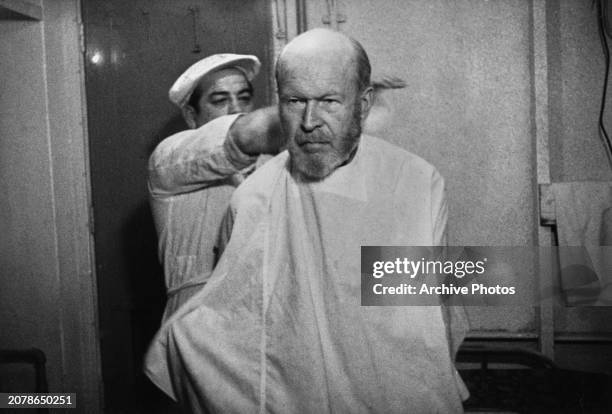 American diplomat Angus I Ward, US Consul General, has a haircut aboard the SS Lakeland Victory after he and his staff were deported, December 1949....