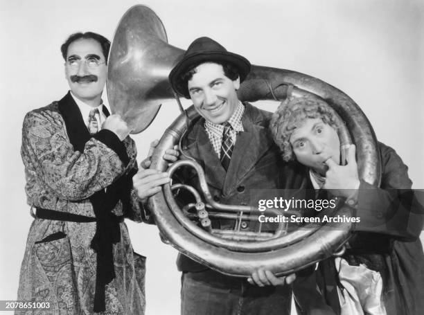 The Marx Brothers Groucho, Chico and Harpo pose with a tuba from the 1937 film 'A Day at the Races'.