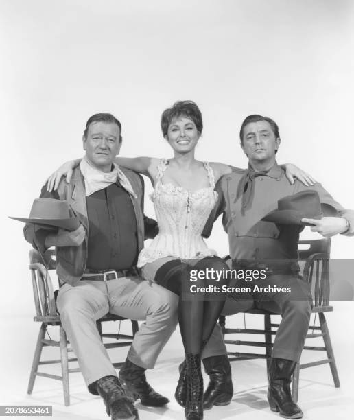 John Wayne, Charlene Holt and Robert Mitchum in studio portrait for the 1966 western 'El Dorado'.