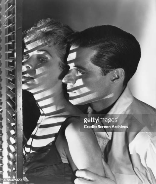 Janet Leigh and John Gavin embrace by window from Alfred Hitchcock's 1960 thriller 'Psycho'.