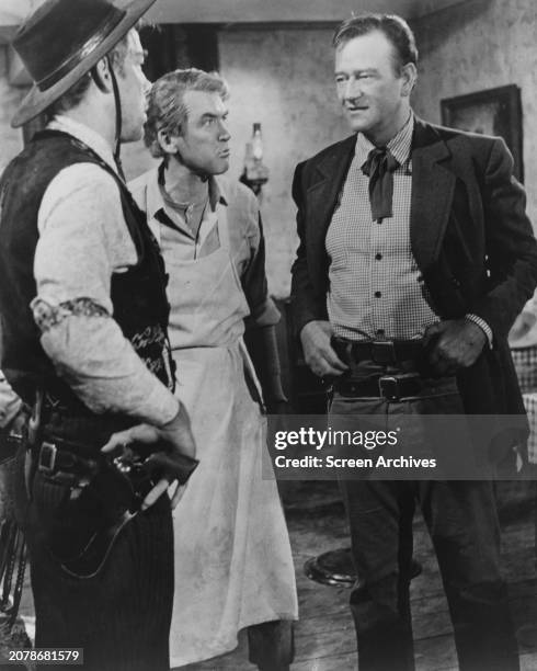 John Wayne and Lee Marvin square up as James Stewart stands beside in a scene from John Ford's 1962 western 'The Man Who Shot Liberty Valance'.