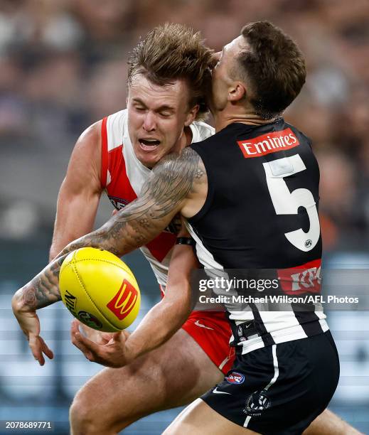 James Jordon of the Swans is tackled by Jamie Elliott of the Magpies during the 2024 AFL Round 01 match between the Collingwood Magpies and the...