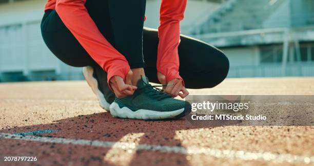 primer plano de una joven atleta asiática que se ata los cordones de los zapatos en preparación para correr el ejercicio de preparación para trotar al aire libre. ejercicio de entrenamiento saludable. - zapatilla fotografías e imágenes de stock